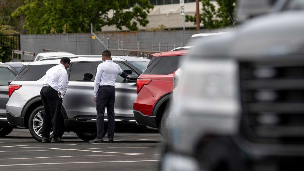 Customers view a vehicle for sale at a Ford Motor Co. dealership in Richmond, California, on July 1, 2021. Eighty percent of new car buyers in January paid more than the manufacturer's suggested retail price, according to data from Edmunds.