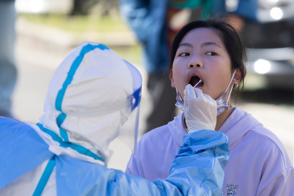 A una niña se le toma una muestra de la boca para una prueba de COVID-19 en Shanghái, China, el 22 de abril de 2022.