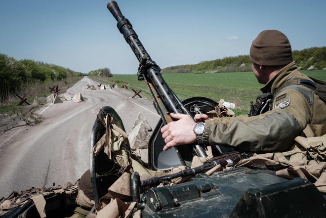 Un soldado ucraniano se sienta en un vehículo blindado de transporte de personal en una carretera cerca de Sloviansk, en el este de Ucrania, el 26 de abril de 2022.
