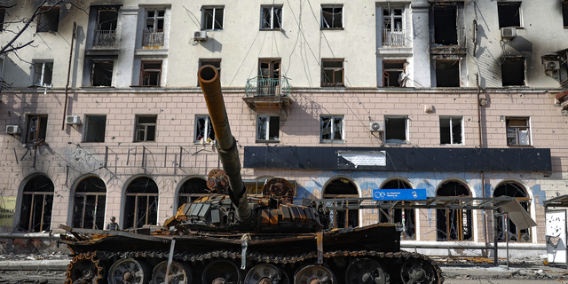Un tanque destruido y un edificio de apartamentos dañado en un área controlada por las fuerzas separatistas respaldadas por Rusia en Mariupol, Ucrania, el martes 26 de abril.