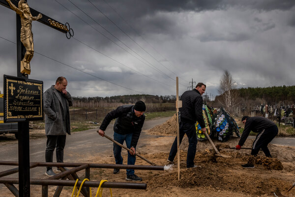 Burying bodies in a cemetery in Bucha, Ukraine, on Tuesday.