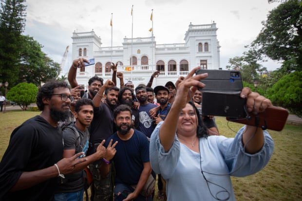 Los manifestantes posan para una selfie grupal mientras devuelven la Oficina del Primer Ministro a las autoridades gubernamentales.