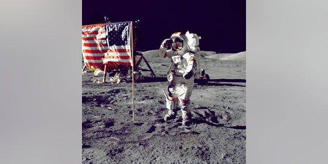 El astronauta Eugene A.  Cernan, el comandante del Apolo 17, saluda a la bandera estadounidense en la superficie lunar durante la actividad extravehicular (EVA) en la reciente misión de alunizaje de la NASA.  unidad lunar "Desafiador" En el fondo izquierdo está la bandera y los Lunar Rovers (LRV) también en el fondo.  Cernan fue el último hombre en caminar sobre la luna después de completar el programa Apolo. 