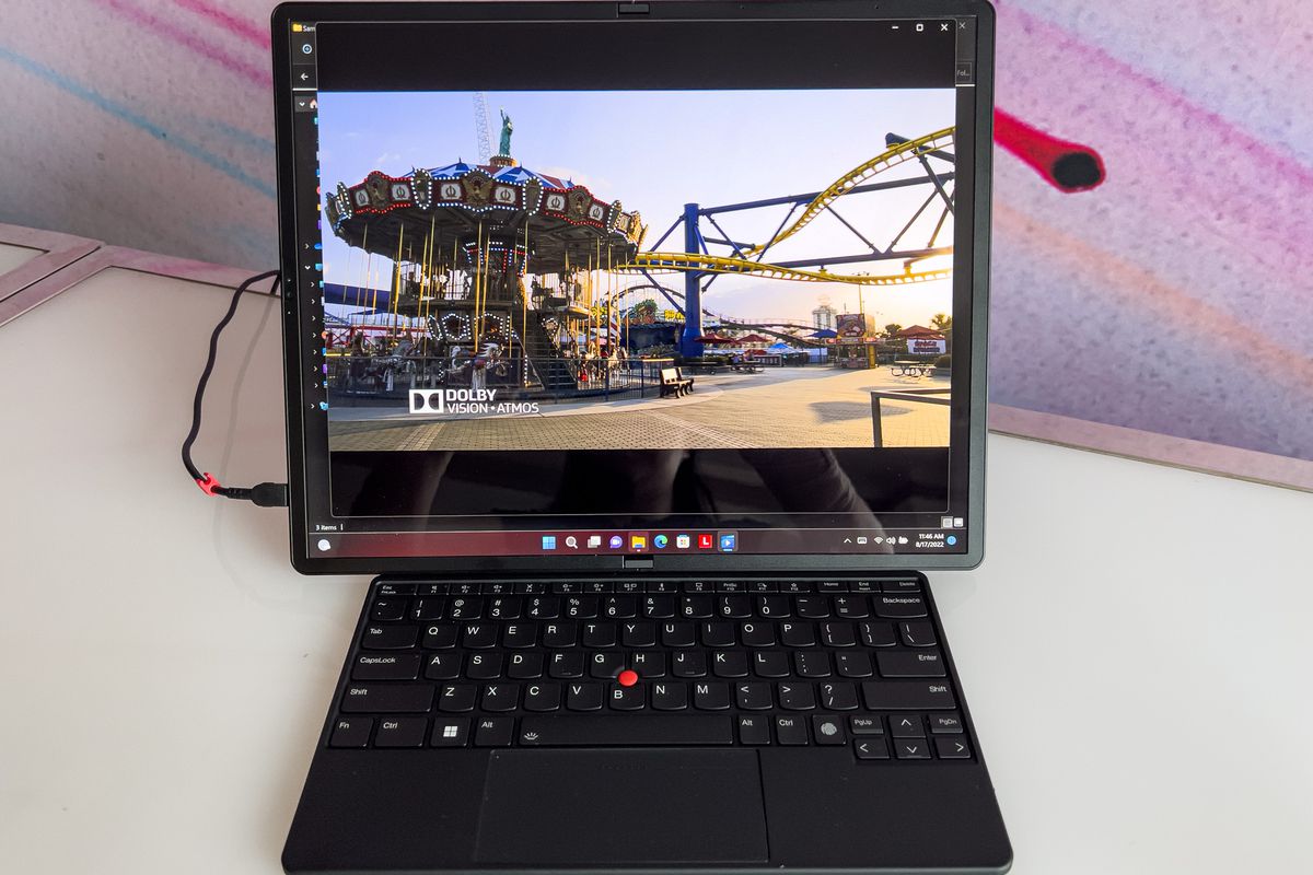 ThinkPad X1 Fold en modo tableta con teclado Bluetooth en el área de visualización.  La pantalla muestra una imagen de vórtice.