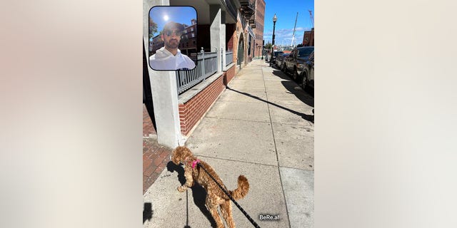 Zack Powers toma una foto de BeReal mientras pasea a su perro, Ruby, en el North End de Boston el 23 de septiembre de 2022.