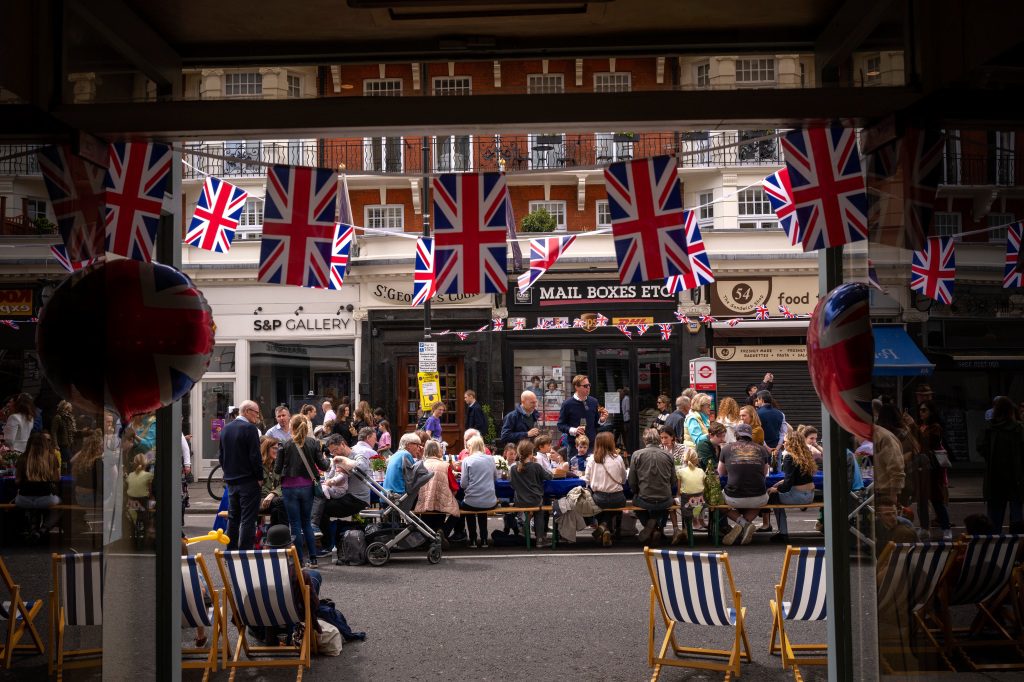 La gente almuerza sentada en grandes mesas en la calle como parte de la Gran Celebración del Almuerzo de Londres.
