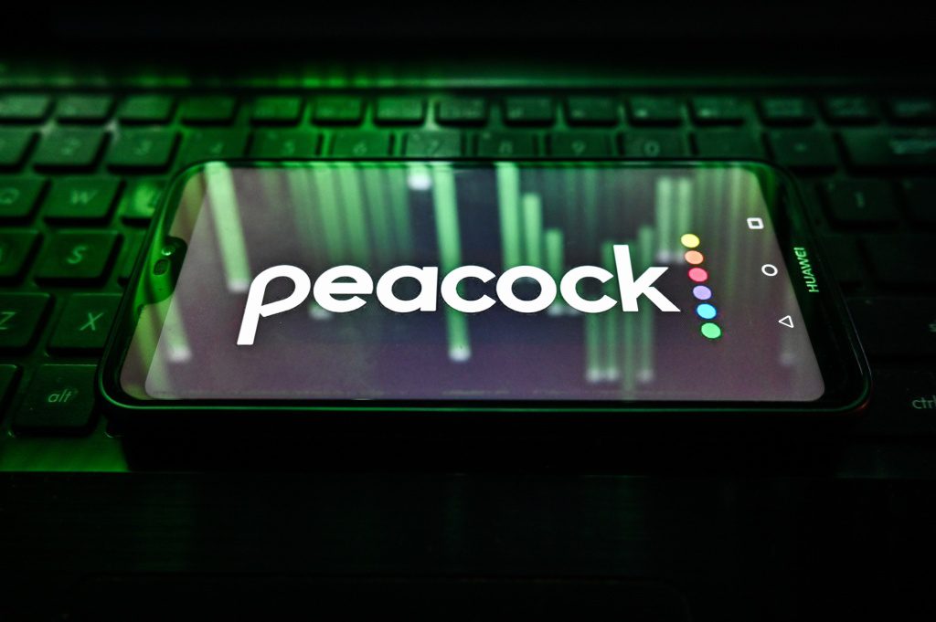 Logotipo de pavo real en el teléfono sentado en el teclado