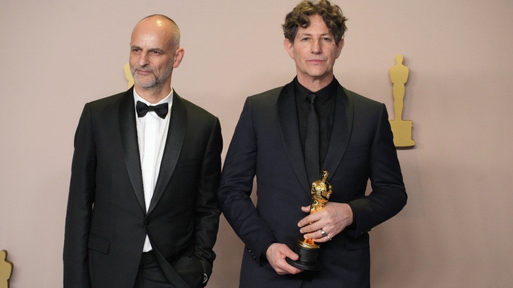 Jonathan Glazer (derecha), ganador del premio a la Mejor Película Internacional por La zona de interés, posa con James Wilson.